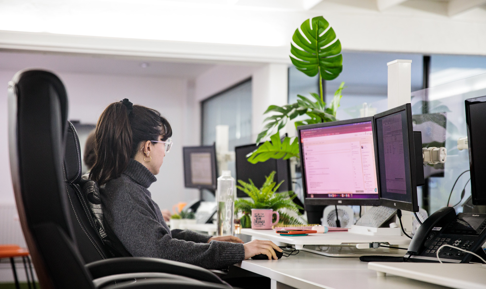 A web designer sat at her desk, working on her computer
